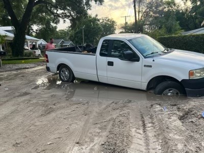 A truck gets stuck in the mud after an aging 2-inch water main breaks.